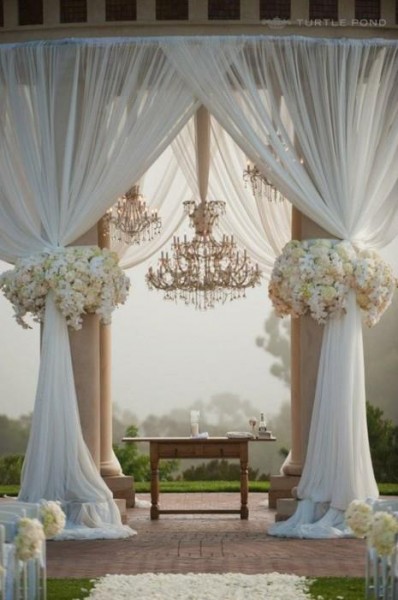 Draped outdoor ceremony spot with chandliers