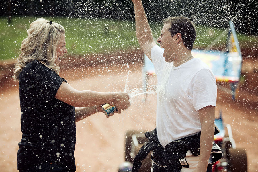 Love On The Speedway, Race Track Engagement Photos With Checkered Flags & Beer Showers